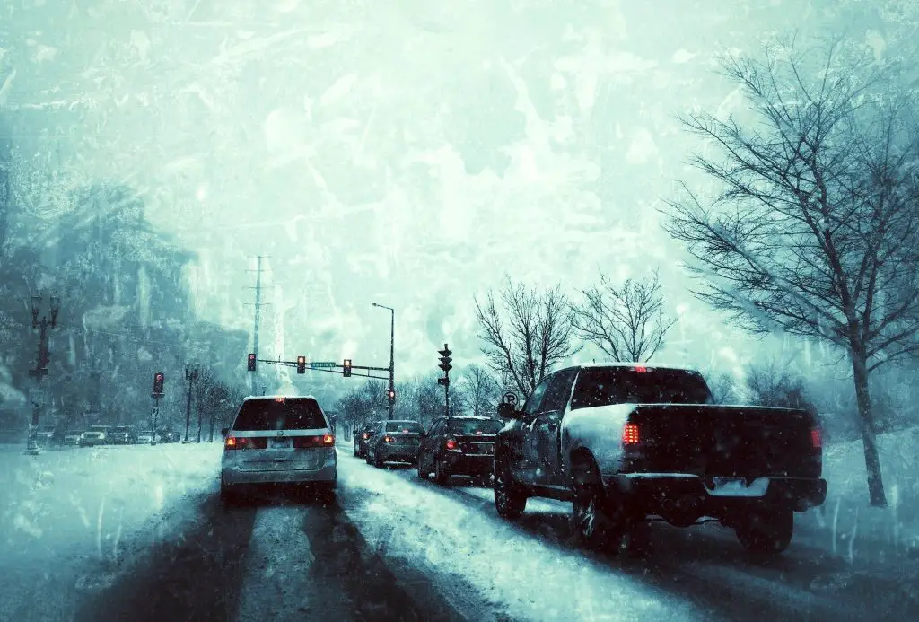 Tail lights of cars stuck in traffic on an icy road.